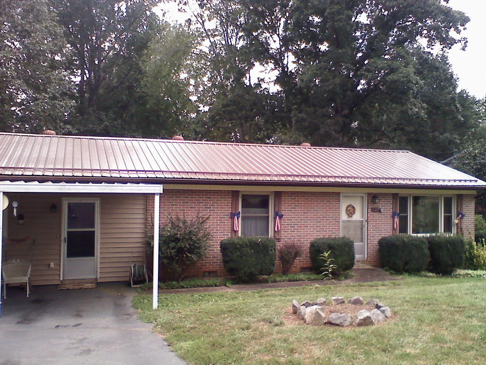 Bronze metal roof and carport on a brick ranch home — Roof Repair work by our crew in King George