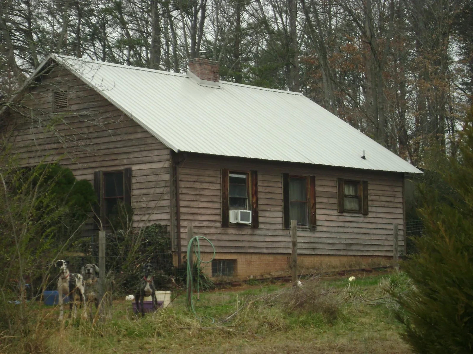 White metal roof on an old wood sided farmhouse, from a Metal Roof Installation job in King George